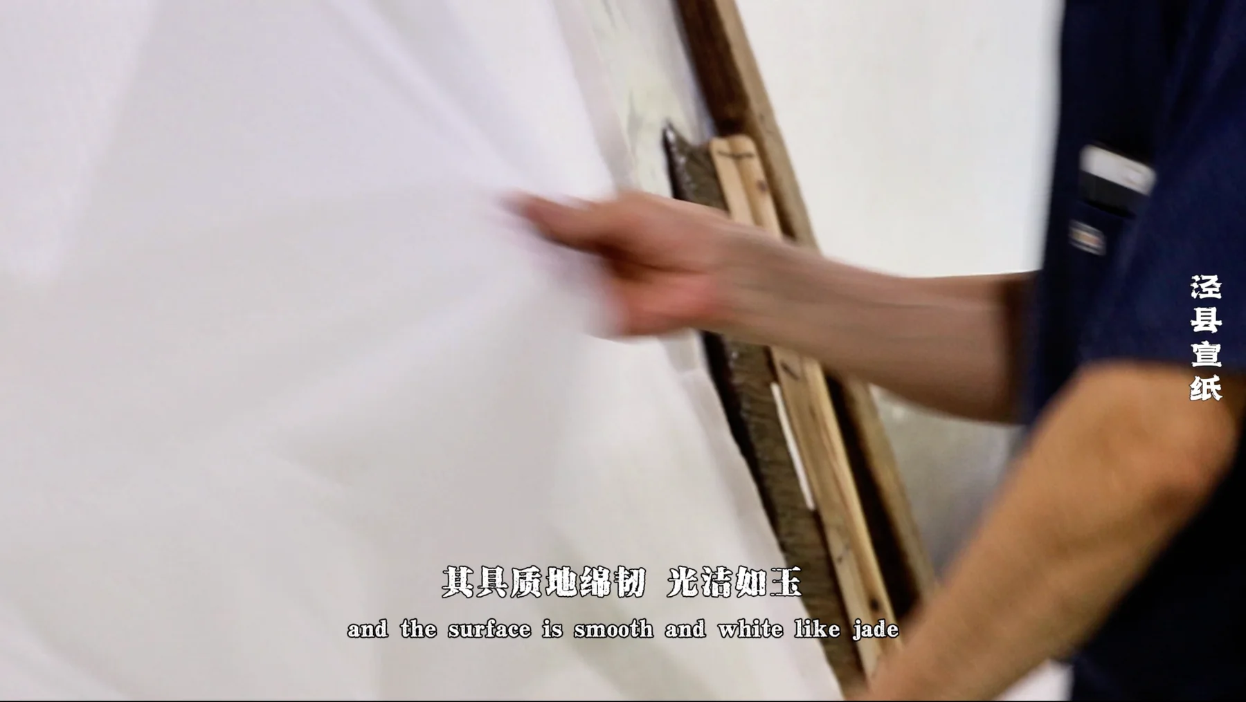 Hand checking the surface of a sheet of Xuan paper